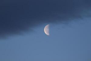 das bunt Blau Sanft Himmel über das Wolken mit Hälfte Mond foto