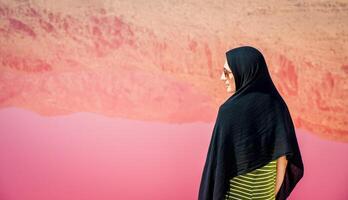 kaukasischer frauentouristenstand auf maharlu-rosa salzseeufer. reiseziel iran in shiraz foto