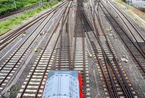 Mehrere Bahngleise mit Abzweigungen an einem Bahnhof perspektivisch und aus der Vogelperspektive foto