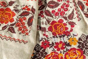 ukrainisch Kleider gestickt Shirt. rot Orange und schwarz Fäden Hintergrund. vyshyvanka ist ein Symbol von Ukraine. Stickerei Kreuz Nähen. National ukrainisch Stich. traditionell Kleidung Symbol foto