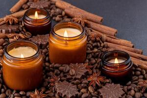 Soja duftend Kerze im ein Krug. Kaffee Bohnen, Anis, Zimt Gewürze. das Kerzen sind Verbrennung. dunkel Hintergrund. foto