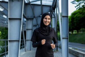 ein aktiv Frau im Hijab Laufen auf ein Stadt Brücke, abbilden Gesundheit, Fitness, und ein aktiv Lebensstil. foto