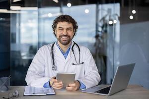 heiter Gesundheitswesen Fachmann im ein Labor Mantel beim Arbeit im ein modern medizinisch Büro, einnehmend mit ein Digital Tablette. foto