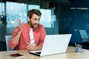 wütend und nervös Geschäftsmann reden auf Anruf aus der Ferne, Mann schreien zu Kollegen online, Boss im Hemd Arbeiten Innerhalb modern Büro mit Laptop beim arbeiten. foto