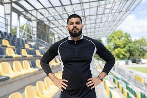 zuversichtlich Athlet Stehen im ein leeren Stadion foto