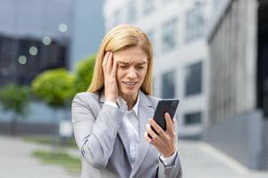 Nahansicht von verärgert Senior Geschäft Frau halten Telefon, weiblich Arbeiter im Geschäft passen Empfang Schlecht Vorwürfe online, Boss mit App auf Smartphone, Gehen draußen Büro Gebäude im Stadt. foto