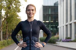 ein passen Frau im Sportbekleidung mit Kopfhörer genießt ein Moment von sich ausruhen während ein städtisch draussen trainieren, ausströmend Vertrauen und Wohlbefinden. foto