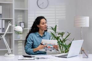 Fachmann spanisch Frau untersucht Unterlagen im ein gut organisiert Zuhause Büro, Arbeiten auf ein Neu Projekt mit ihr Laptop. foto