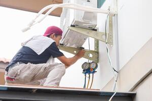 Techniker Mann Installieren Neu Luft Conditioner, Handwerker Bedienung zum Reparatur und Instandhaltung von Luft Conditioner foto