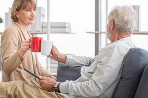 Senior Paar Ausgaben Zeit zusammen im das Leben Zimmer, im Ruhestand Mann und Frau Trinken Kaffee, und Tee zusammen, glücklich Familie Konzepte foto