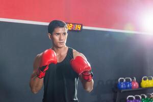 stark jung Athlet Sportler muay thailändisch Boxer Kampf im ein Fitnessstudio, muskulös gut aussehend Boxen Mann Kämpfer foto