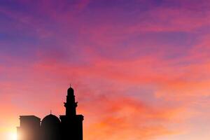 das Silhouette von ein Moschee im Sonnenuntergang verschwommen Hintergrund foto