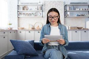 jung schön asiatisch weiblich Schüler empfangen glücklich Brief von Universität foto