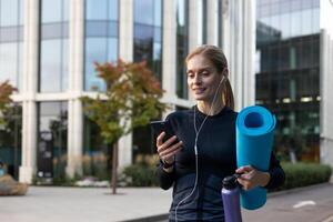 froh Frau gehen zu trainieren, Athlet mit Yoga Matte mit online Dating App und Joint Ausbildung. foto