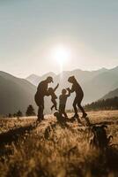 Familie Silhouette beschäftigt, verlobt im spielerisch Aktivitäten beim Park mit Berg foto