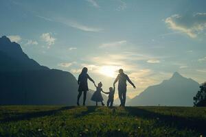 Familie Silhouette spielen glücklich im Park mit majestätisch Berg Hintergrund foto