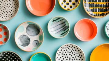 ein Sammlung von Keramik Geschirr im ein geometrisch Muster mit Fett gedruckt Pops von Farbe und verschiedene Teller Größen zum anders Kurse. foto