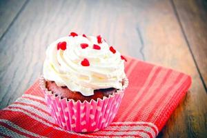 Kuchen mit Sahne, Cupcake auf holzigem Hintergrund. foto