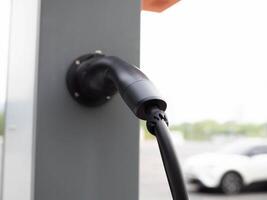 ev Stecker im Bahnhof ev Kopieren Raum Auto Automobil Batterie Technologie Kabel Fahrzeug Energie Leistung Transport Umgebung Ladegerät Grün Ökologie Hybrid Automobil elektrisch Auto modern verlängerbar Motor foto