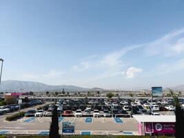 Affines, Griechenland - - 20 August 2023. enorm Parkplatz Menge mit geparkt Autos gegen das Hintergrund von ein Berg Angebot foto