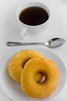 Donuts und ein Tasse von Tee zum Essen auf entspannend Zeit foto