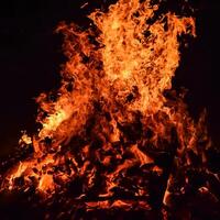 feuerflammen auf schwarzem hintergrund, lodernder feuerflammentexturhintergrund, schön, das feuer brennt, feuerflammen mit holz und kuhdunglagerfeuer foto