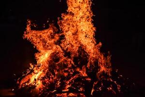 feuerflammen auf schwarzem hintergrund, lodernder feuerflammentexturhintergrund, schön, das feuer brennt, feuerflammen mit holz und kuhdunglagerfeuer foto