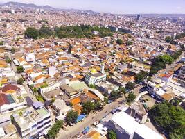 Stadtbild von ein übervölkert Wohn Kreis im bandung Stadt. Aussicht von das dicht Wohn Landschaft im Downton. Antenne Fotografie. Sozial Themen. Schuss von ein fliegend Drohne foto