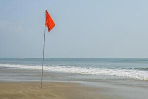 rot Flagge auf Strand auf Meer oder Ozean wie ein Symbol von Achtung. das Meer Zustand ist berücksichtigt gefährlich und Schwimmen ist verboten. foto