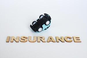 Versicherung Text mit Kopf Nieder Spielzeug Auto Hintergrund. Auto Versicherung Konzept foto