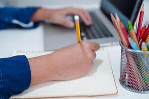 asiatisch Teenager Schüler schreiben Hausaufgaben mit Laptop Computer, Lernen Universität Bildung Konzept. foto