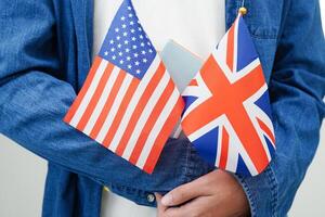 Lernen Englisch, asiatisch Teenager Schüler halten Buch mit Flagge zum Sprache Programm Bildung. foto