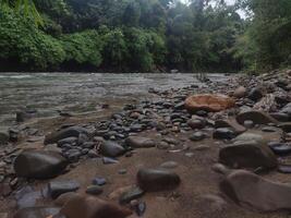 Felsen beim ein friedlich Fluss im ein tropisch Wald von Süd-Ost Asien foto