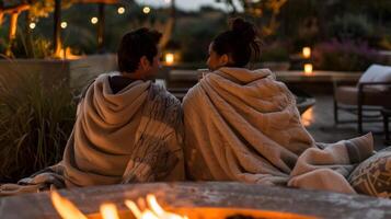 Paare kuschelte oben im gemütlich wirft nippen auf ihr Getränke während genießen das Wärme von das Feuer Grube und Sanft Kerzenlicht. 2d eben Karikatur foto