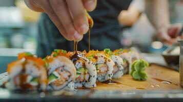 ein Schüler vorsichtig Hinzufügen ein Nieselregen von Soja Soße zu ihr fertig Sushi rollen foto