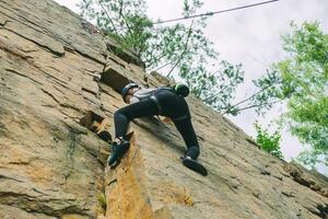 jung sportlich Frau im Ausrüstung tun Felsen Klettern draußen. Ausbildung Bereich zum draussen Aktivitäten. extrem Sport. foto