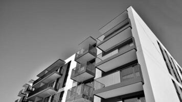 Fragment von ein Fassade von ein Gebäude mit Fenster und Balkone. modern Wohnung Gebäude auf ein sonnig Tag. Fassade von ein modern Wohnung Gebäude. schwarz und Weiß. foto