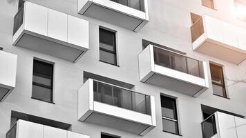 Fragment von das Gebäude Fassade mit Fenster und Balkone. modern Wohnung Gebäude auf ein sonnig Tag. Fassade von ein modern Wohn Gebäude. schwarz und Weiß. foto