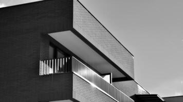 Fragment von das Gebäude Fassade mit Fenster und Balkone. modern Wohnung Gebäude auf ein sonnig Tag. Fassade von ein modern Wohn Gebäude. schwarz und Weiß. foto