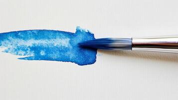 schließen oben von ein Blau Aquarell Pinsel Trinkgeld auf ein Weiß Hintergrund foto