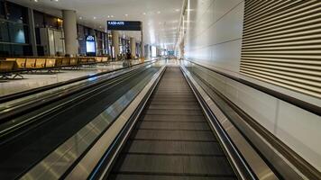 modern Flughafen Innere mit ein leeren ziehen um Gehweg, glatt Design, und zeitgenössisch Beleuchtung, relevant zum Geschäft Reise und Transport Themen foto