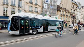 Öko freundlich Transport im Paris, mit Radfahrer und ein elektrisch Bus auf ein wolkig Tag, vorbildlich nachhaltig städtisch Mobilität, Paris, Frankreich, April 14., 2024 foto