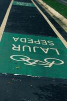Fahrrad Fahrbahn Zeichen im Gelb mit solide Linien auf Asphalt Straße im Indonesien foto