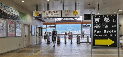 Kyoto, Japan auf 1 Oktober 2023. Touristen sind Gehen beim das Saga Arashiyama Zug Bahnhof foto