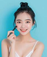 Porträt von ein schön lächelnd asiatisch Frau mit ein glatt und sauber Gesicht. Haut Pflege Werbung Konzept zum Jugend mit hell aqua Blau Hintergrund. foto