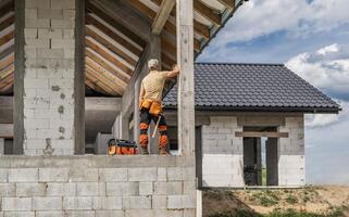 Konstruktion Seite? ˅ Arbeiter und das neu entwickelt Beton Ziegel Haus foto