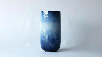ein hoch zylindrisch Vase mit ein Gradient Glasur bewirken beginnend von ein tief Marine Blau beim das Unterseite und Fading in ein Licht Himmel Blau beim das oben. foto