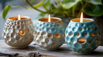 ein Trio von Keramik Teelicht Kerze Inhaber mit ein glänzend Fertig und ein holperig Textur erinnernd von Seepocken Muscheln. foto