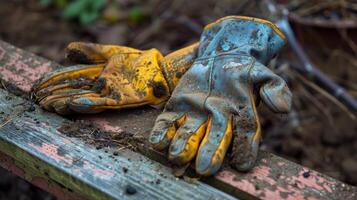 ein Paar von getragen Gartenarbeit Handschuhe ruhen auf ein in der Nähe Bank Beweise von ein Tag verbraucht graben im das Erde und finden Trost im das Prozess foto