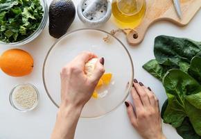 Schritt für Schritt Zubereitung von Spinat, Avocado und Orangensalat. Schritt 2 - Orange für die Sauce auspressen foto